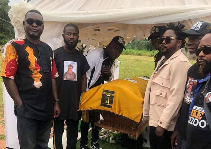 Remains of Michael Aboh lying in state as former group member, Ibrahim Al-Hassan (3rd R) and others pose for a shot.