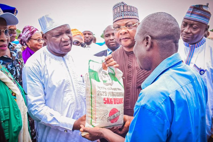 Deputy Governor of Niger State, Comrade Yakubu  Garba, Commissioner for Humanitarian and Disaster Management,  Ahmed  Suleiman presenting food items to one of the beneficiaries.