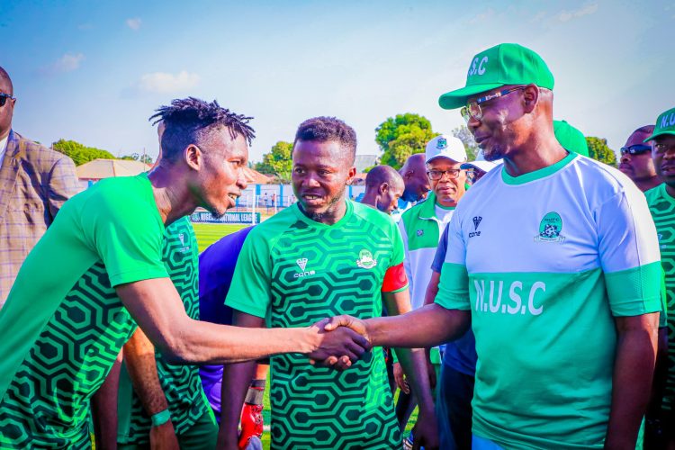 Governor Abdullahi Sule ( r) in a handshake with one of the players after the match