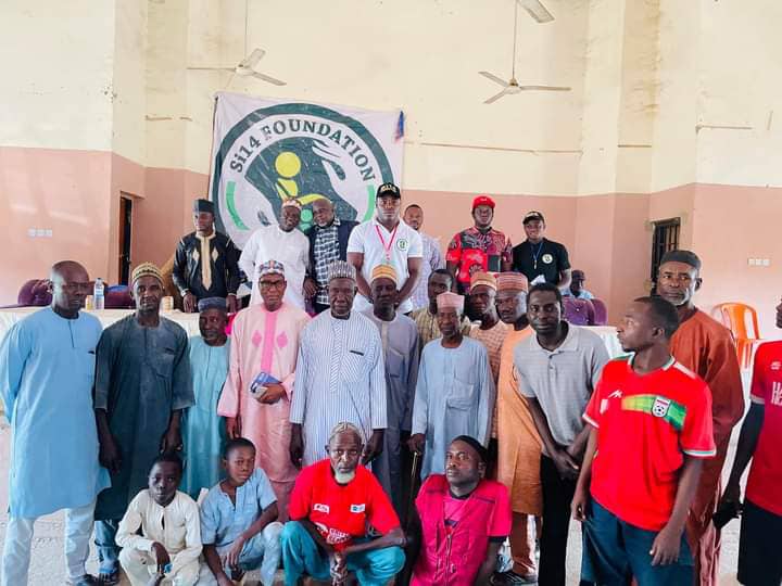 Super Eagles striker, Sunusi Ibrahim in a group photograph with some of the beneficiaries.