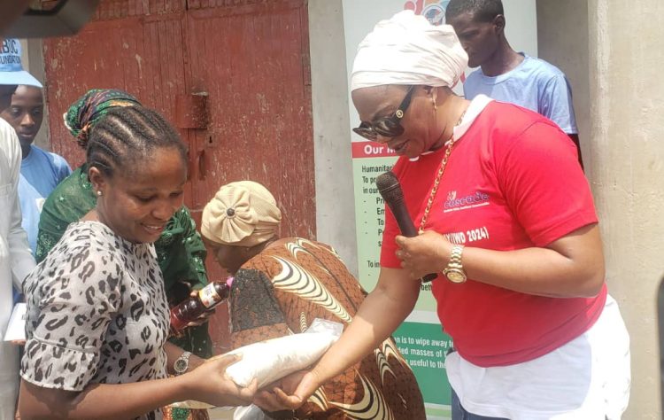 Nasarawa State Commissioner for Humanitarian Affairs and NGOs, Hon Margaret Elayo (r) distributing food items to one of the beneficiaries during the event to commemorate the International Women's Day